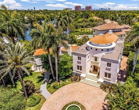 an aerial view of a house with a yard and lake view