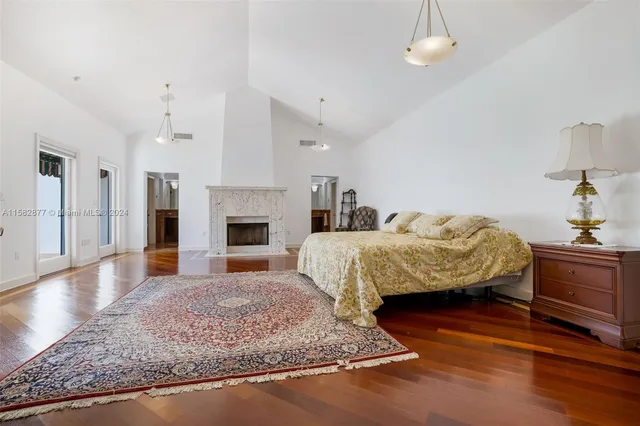 a spacious bedroom with a bed and wooden floor