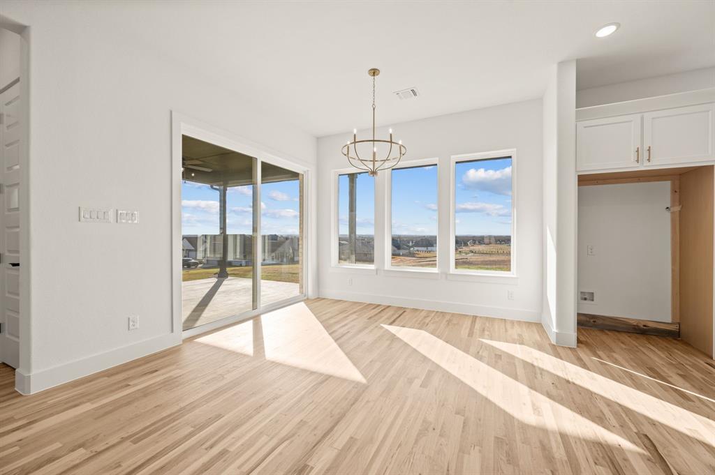 412 Caprock Lane Azle, TX 76020 - Photo 11 of 40 a view of an empty room with wooden floor and a window