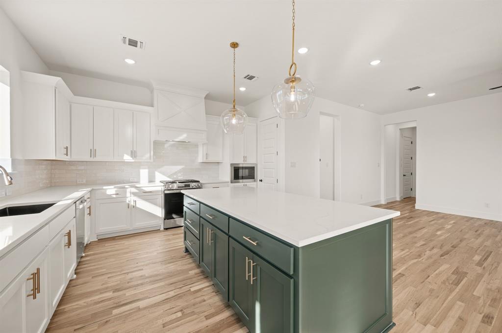 412 Caprock Lane Azle, TX 76020 - Photo 13 of 40 a kitchen with a stove sink and cabinets