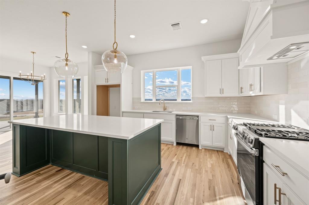 412 Caprock Lane Azle, TX 76020 - Photo 17 of 40 a kitchen with stainless steel appliances granite countertop a sink stove and refrigerator
