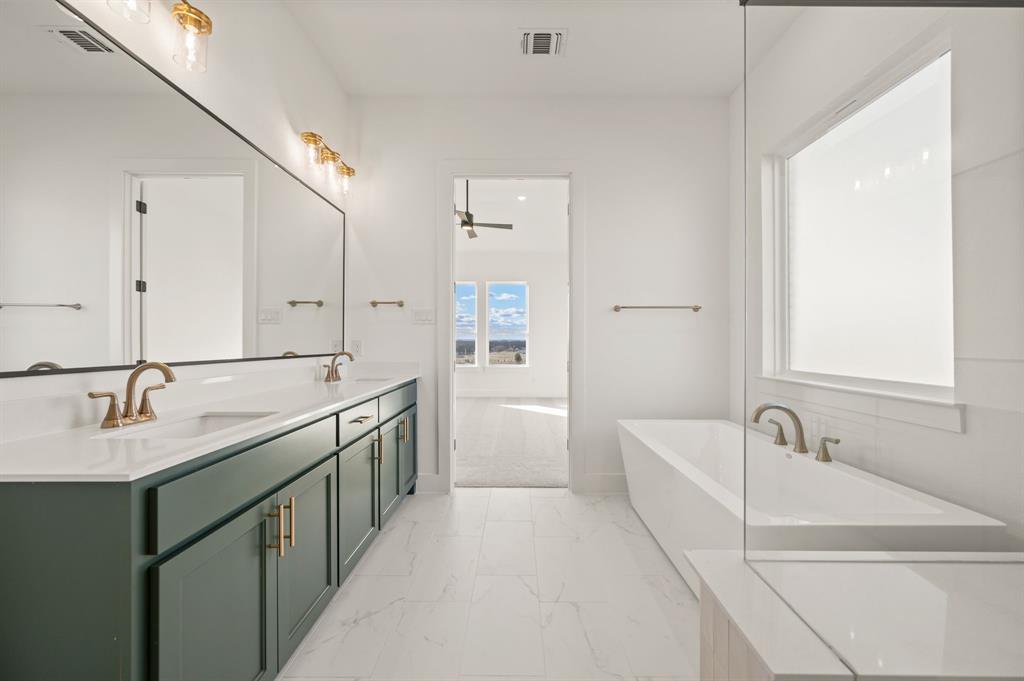 412 Caprock Lane Azle, TX 76020 - Photo 22 of 40 a bathroom with a granite countertop sink and a bathtub