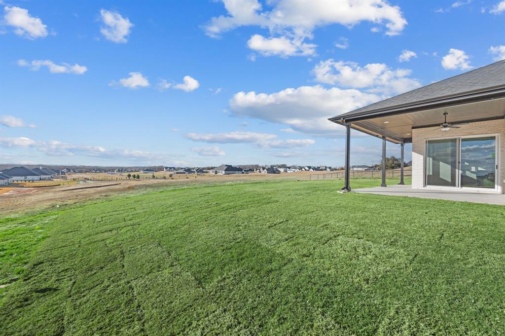 412 Caprock Lane Azle, TX 76020 - Photo 35 of 40 a view of a big yard with table and chairs under an umbrella