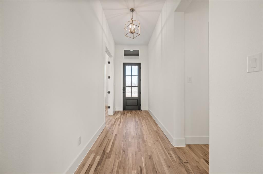 412 Caprock Lane Azle, TX 76020 - Photo 4 of 40 a view of a hallway with wooden floor and a bathroom