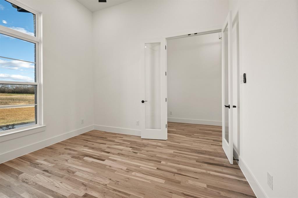 412 Caprock Lane Azle, TX 76020 - Photo 6 of 40 a view of an empty room with wooden floor and a window