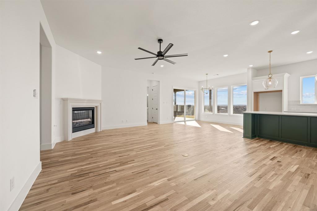 412 Caprock Lane Azle, TX 76020 - Photo 8 of 40 a view of an empty room and kitchen view with wooden floor