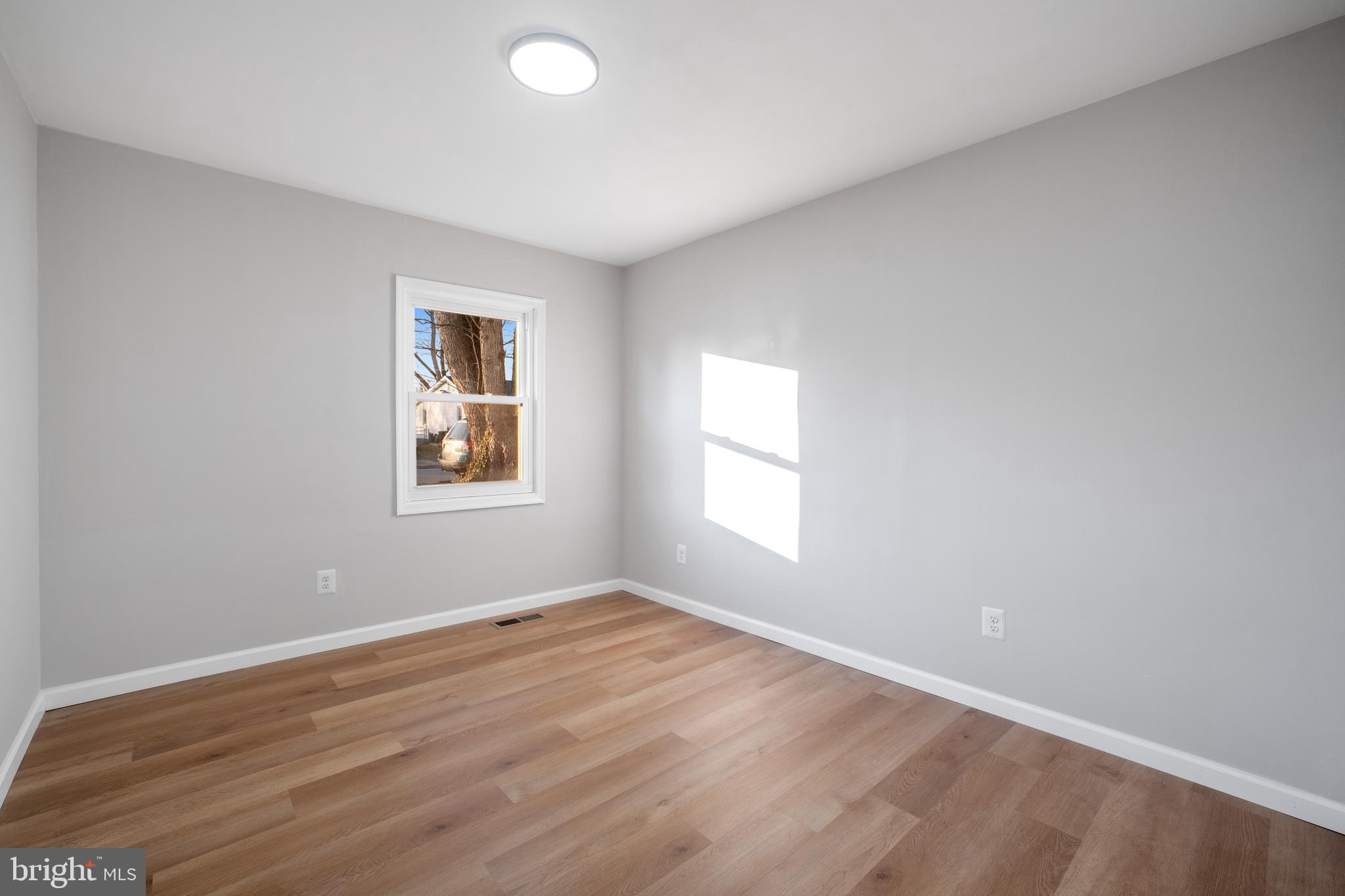 497 Bruce Avenue Odenton, MD 21113 - Photo 14 of 38 a view of an empty room with wooden floor and a window