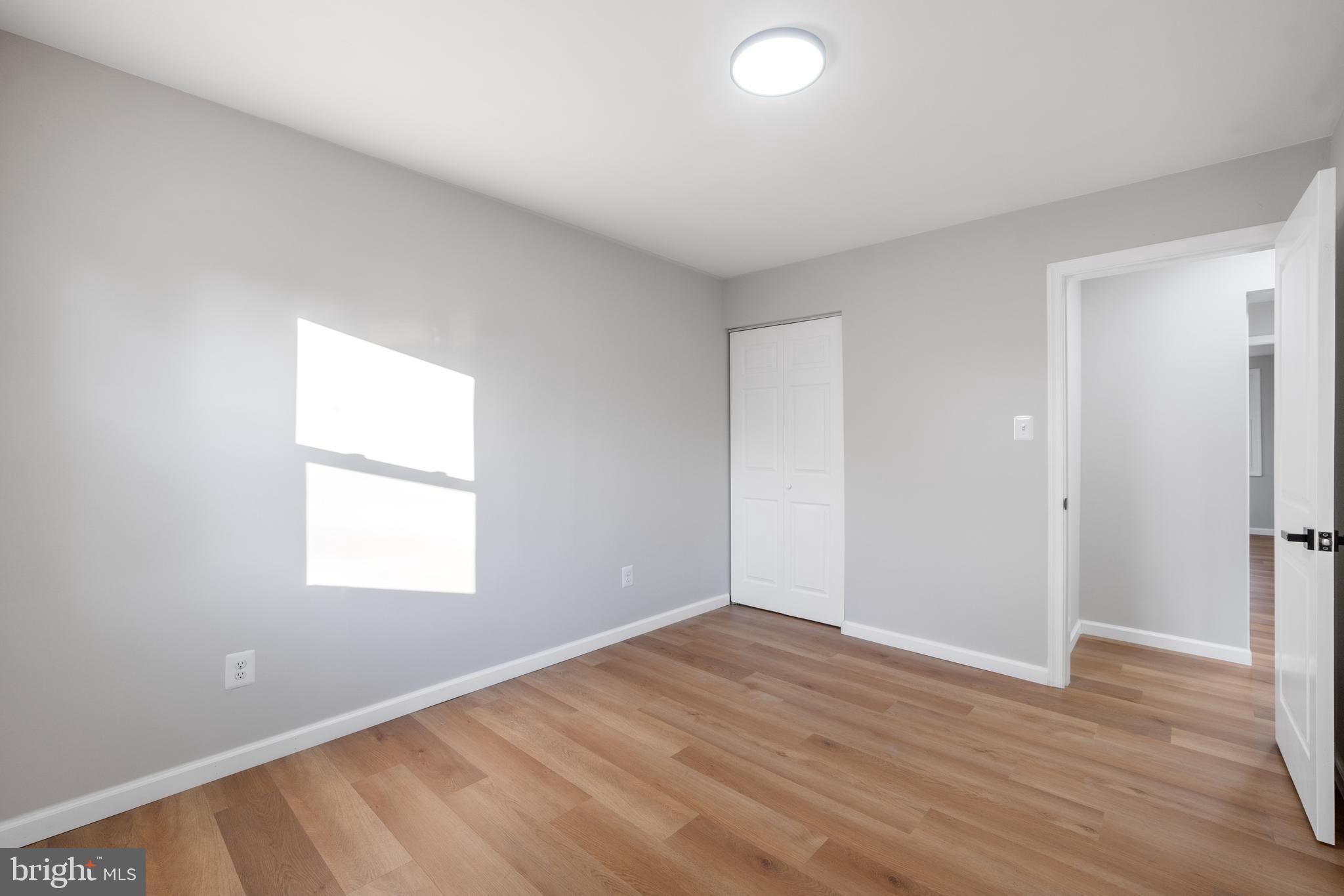 497 Bruce Avenue Odenton, MD 21113 - Photo 15 of 38 an empty room with wooden floor and windows