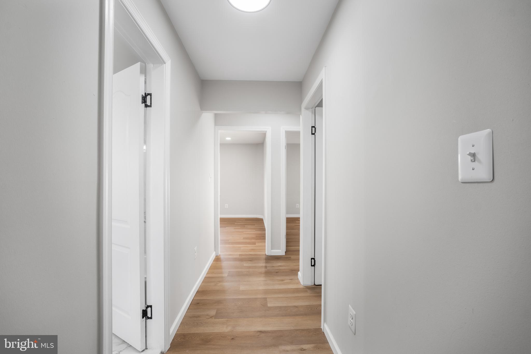 497 Bruce Avenue Odenton, MD 21113 - Photo 26 of 38 a view of a hallway with wooden floor and a bathroom