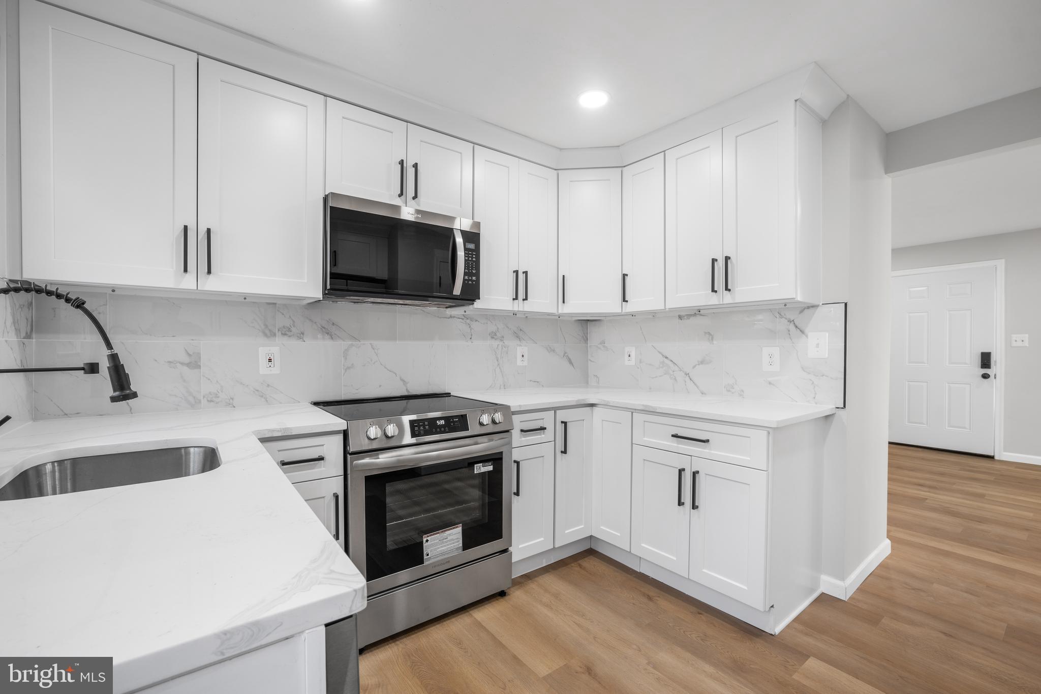 497 Bruce Avenue Odenton, MD 21113 - Photo 4 of 38 a kitchen with granite countertop white cabinets and stainless steel appliances
