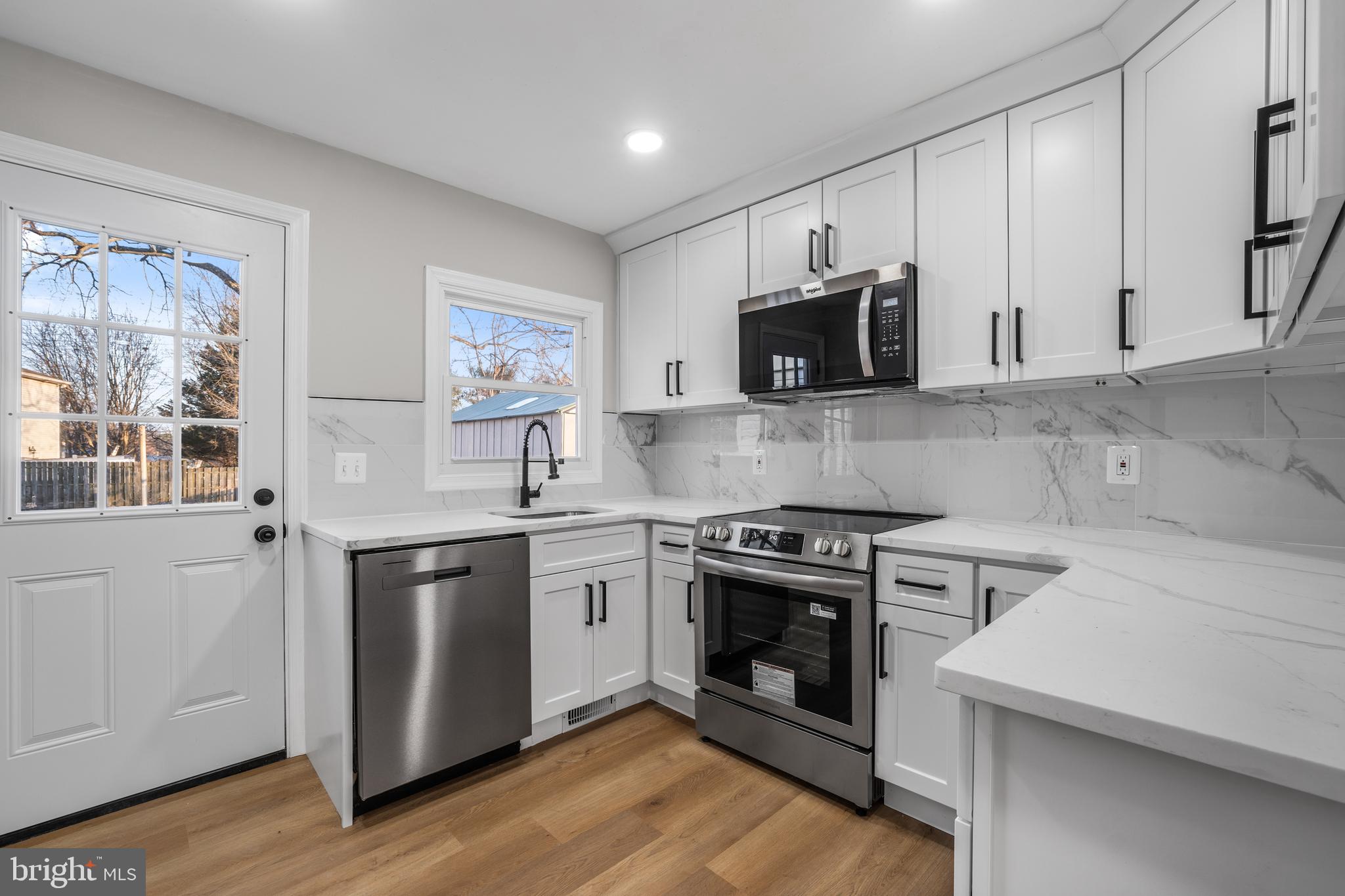 497 Bruce Avenue Odenton, MD 21113 - Photo 5 of 38 a kitchen with stainless steel appliances granite countertop a stove top oven microwave and sink
