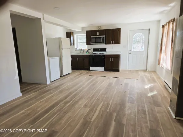 a large kitchen with stainless steel appliances a refrigerator and a stove top oven
