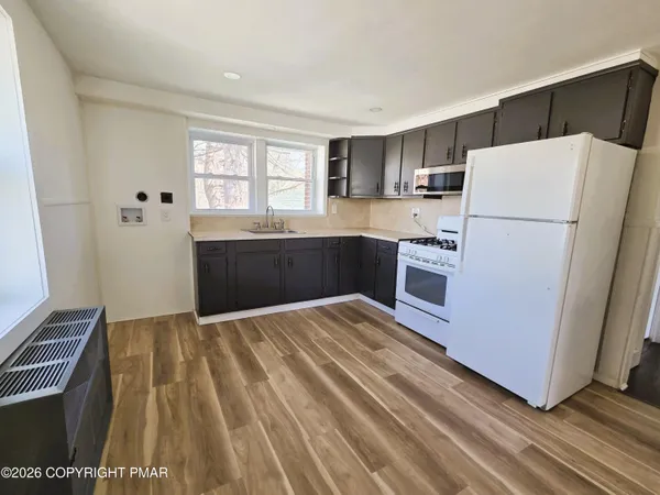 a kitchen with a refrigerator and a stove top oven