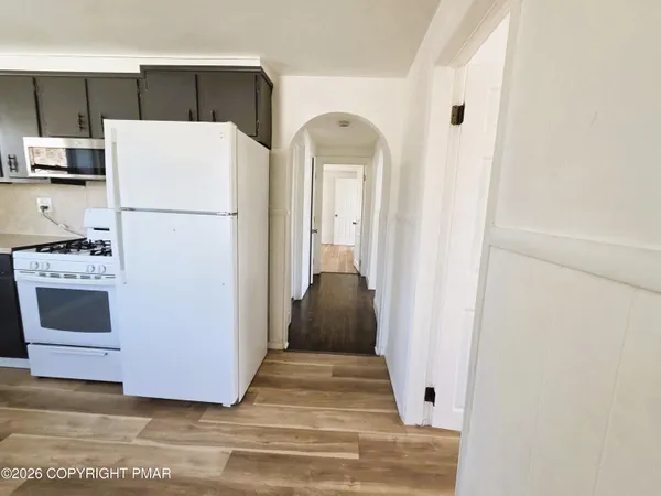 a view of a kitchen from a hallway