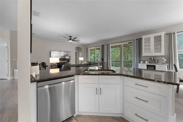 a kitchen with granite countertop white cabinets and white appliances