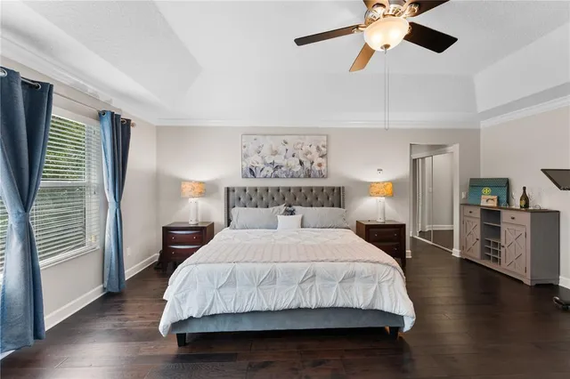 a spacious bedroom with a bed and wooden floor