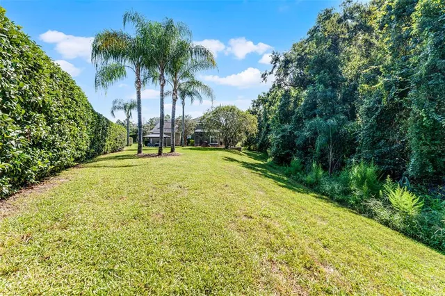 an aerial view of a house with a yard and lake view