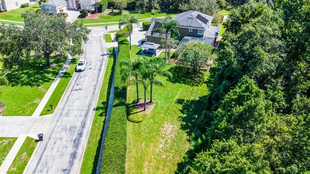 an aerial view of a houses with a yard and lake view