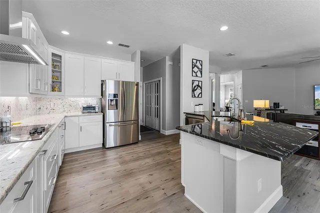 a kitchen with stainless steel appliances granite countertop a sink stove and refrigerator