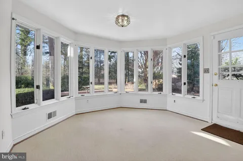 a view of an empty room with windows and entrance
