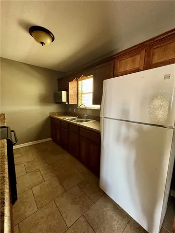 a kitchen with stainless steel appliances granite countertop a refrigerator and a sink