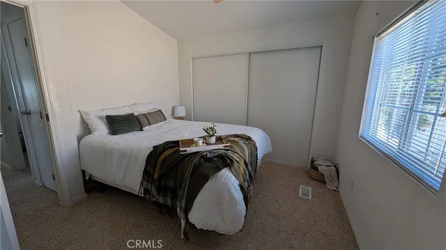 a bed sitting in a bedroom next to a window