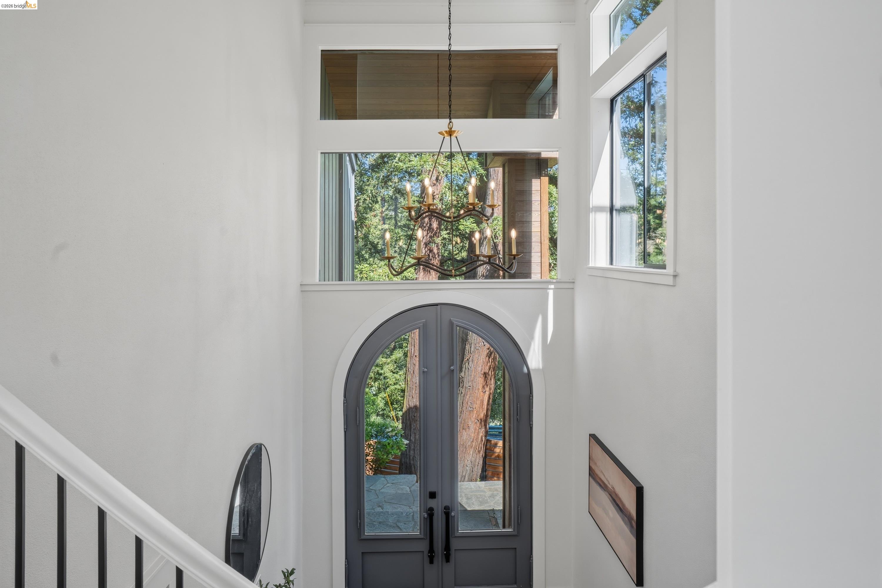 4120 Happy Valley Road Lafayette, CA 94549 - Photo 15 of 48 Double arched entry doors with transom windows, a multi-pane glass chandelier, and white-painted walls