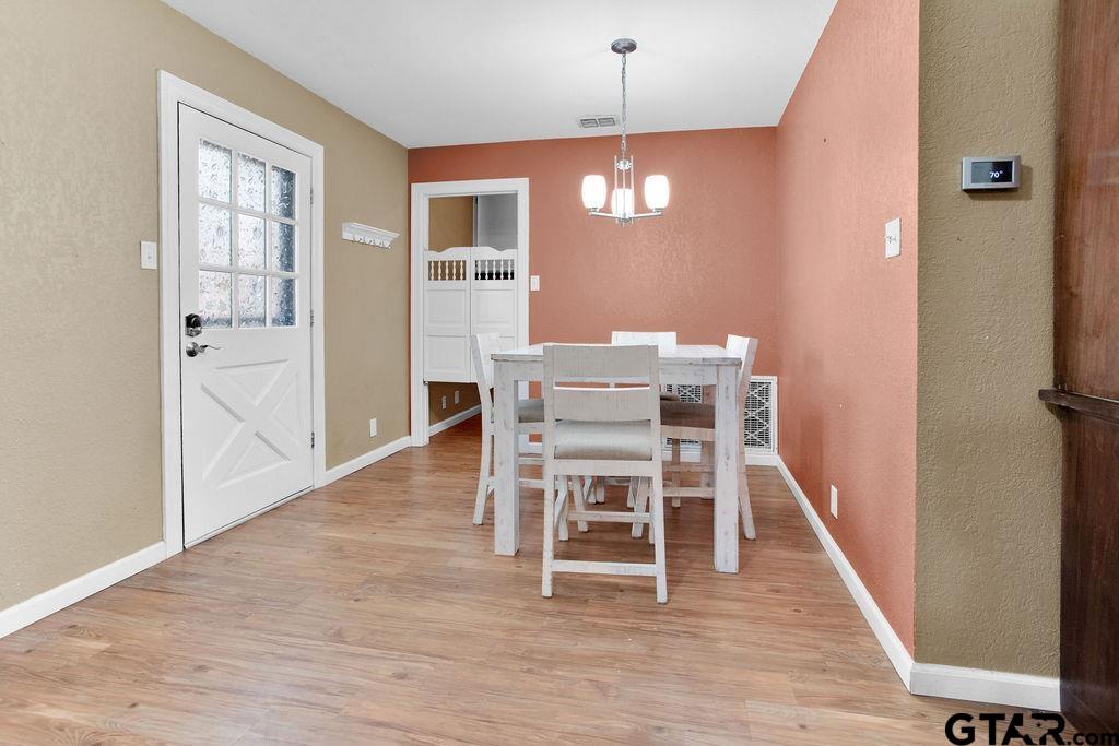 213 Treetop Lane Hideaway, TX 75771 - Photo 15 of 48 a view of a dining room with furniture and wooden floor