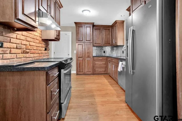 a kitchen with stainless steel appliances granite countertop a refrigerator a sink and dishwasher
