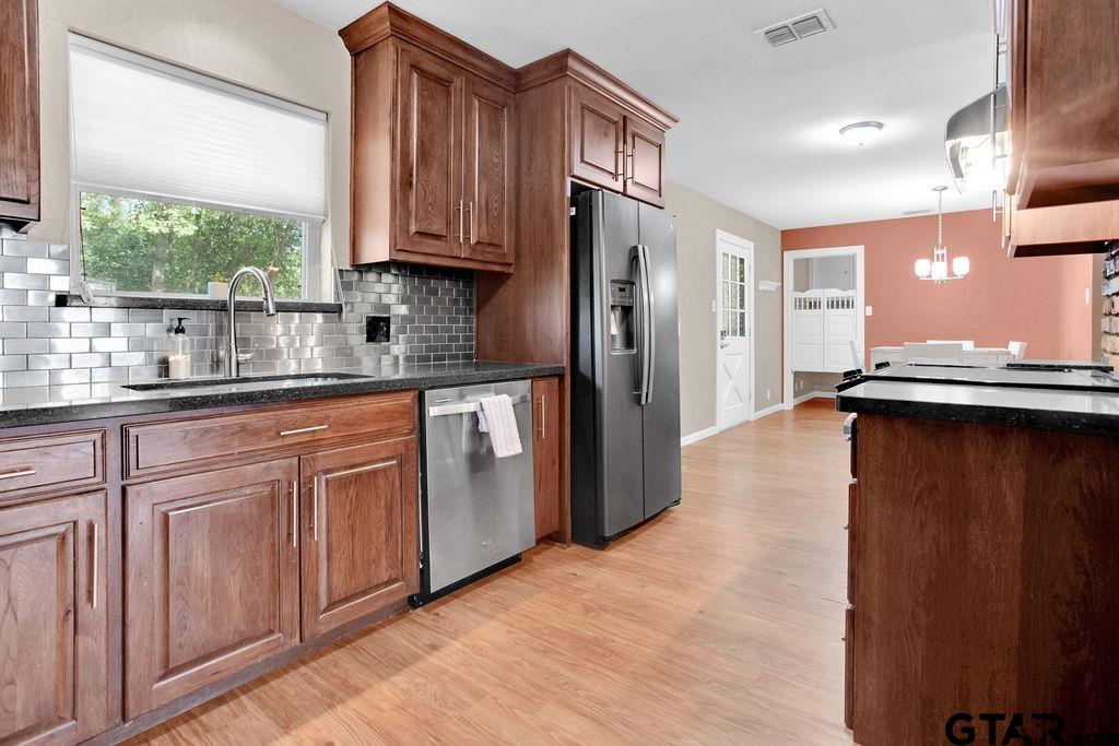 213 Treetop Lane Hideaway, TX 75771 - Photo 20 of 48 a kitchen with stainless steel appliances granite countertop a refrigerator and a sink