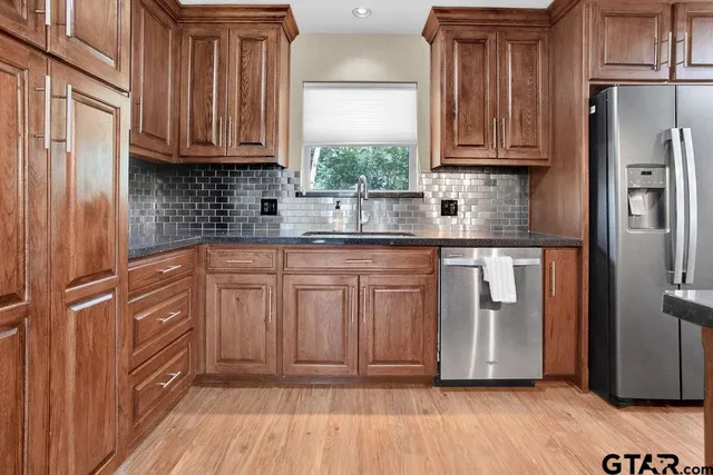 a kitchen with stainless steel appliances granite countertop a refrigerator and cabinets