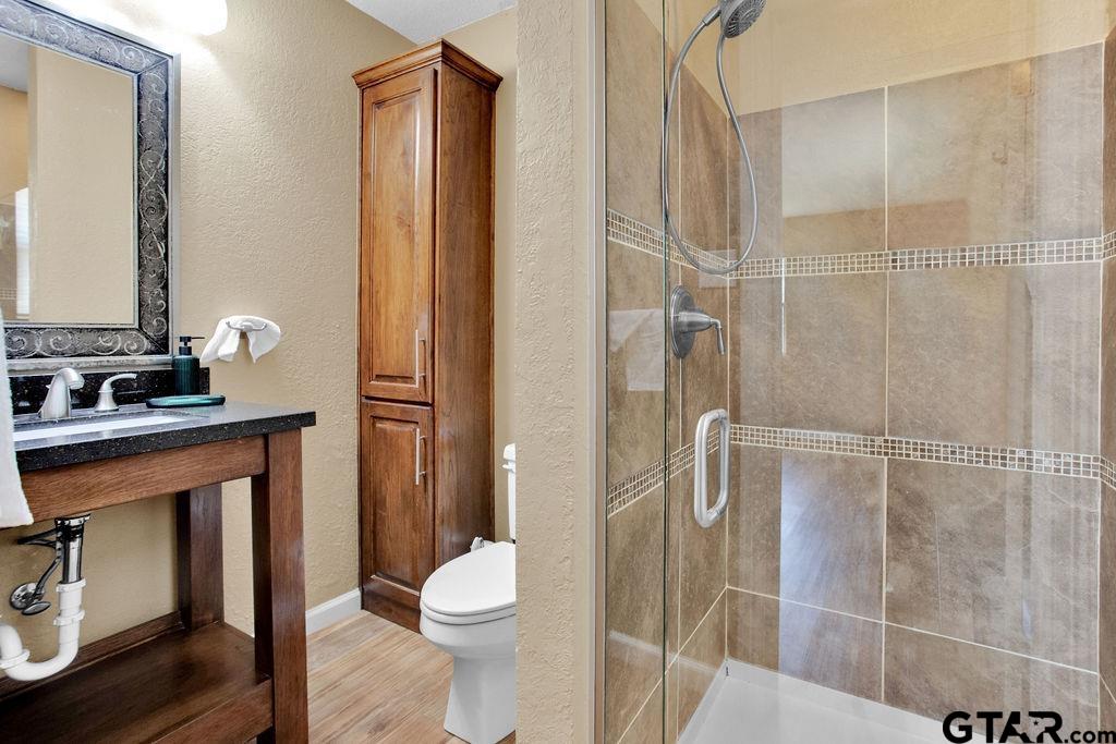 213 Treetop Lane Hideaway, TX 75771 - Photo 25 of 48 a bathroom with a shower a toilet and sink