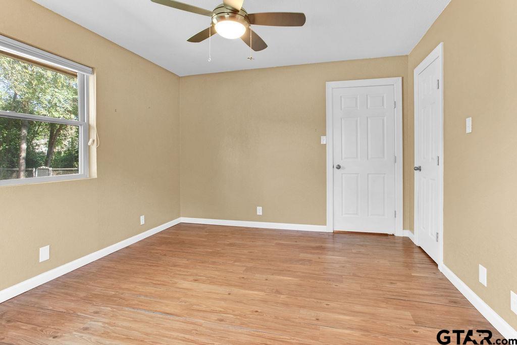 213 Treetop Lane Hideaway, TX 75771 - Photo 30 of 48 a view of an empty room with wooden floor and a window