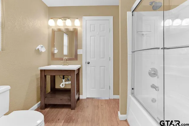 a bathroom with a sink a toilet and shower