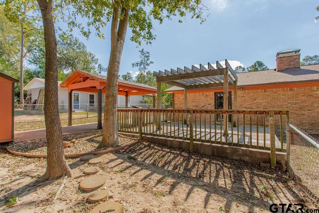 213 Treetop Lane Hideaway, TX 75771 - Photo 43 of 48 a view of a brick house with large windows and a table