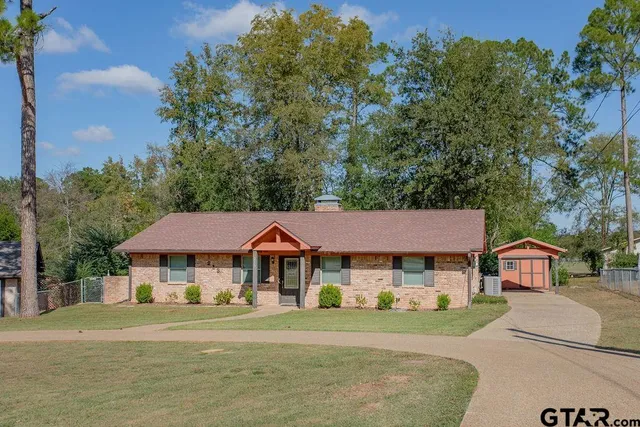 a front view of a residential houses with yard and green space