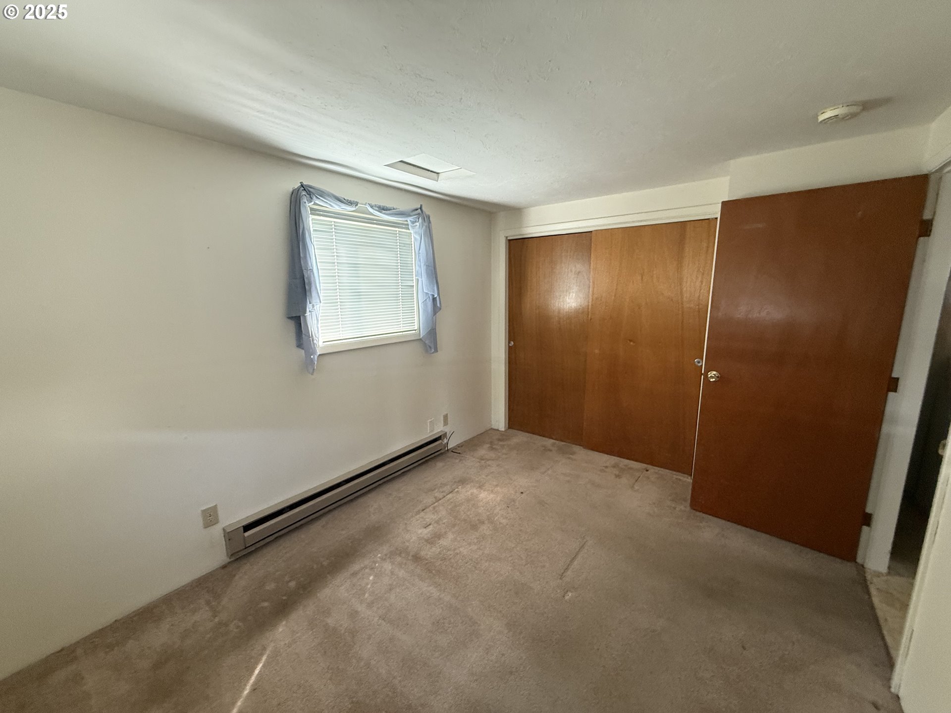 410 Birch Street Drain, OR 97435 - Photo 11 of 14 an empty room with windows and entrance to other room