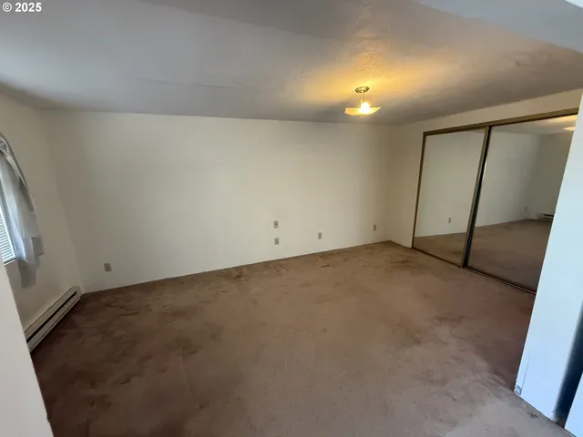 an empty room with closet and mirror