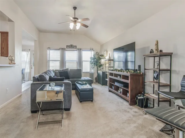 a living room with furniture a ceiling fan and a window