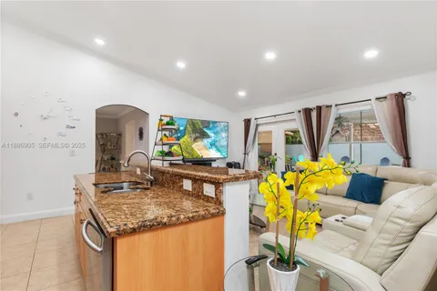 a living room with furniture a flat screen tv and a large window