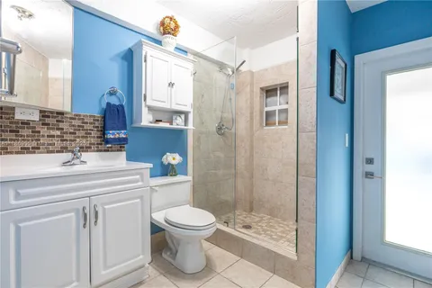 a bathroom with a granite countertop sink mirror and toilet