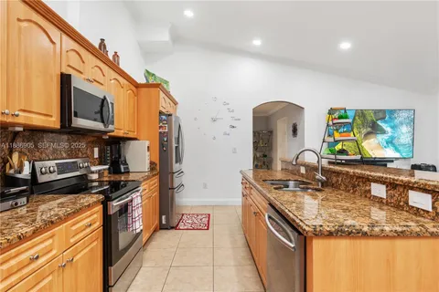a kitchen with stainless steel appliances granite countertop a sink stove and cabinets