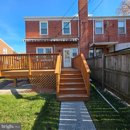 a view of a house with backyard and wooden deck