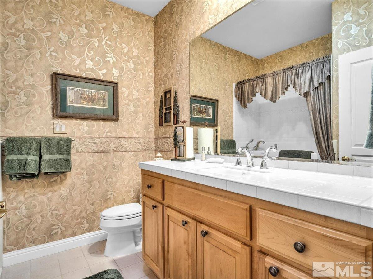 2034 Comstock Drive Gardnerville, NV 89410 - Photo 17 of 40 a bathroom with a toilet sink and mirror