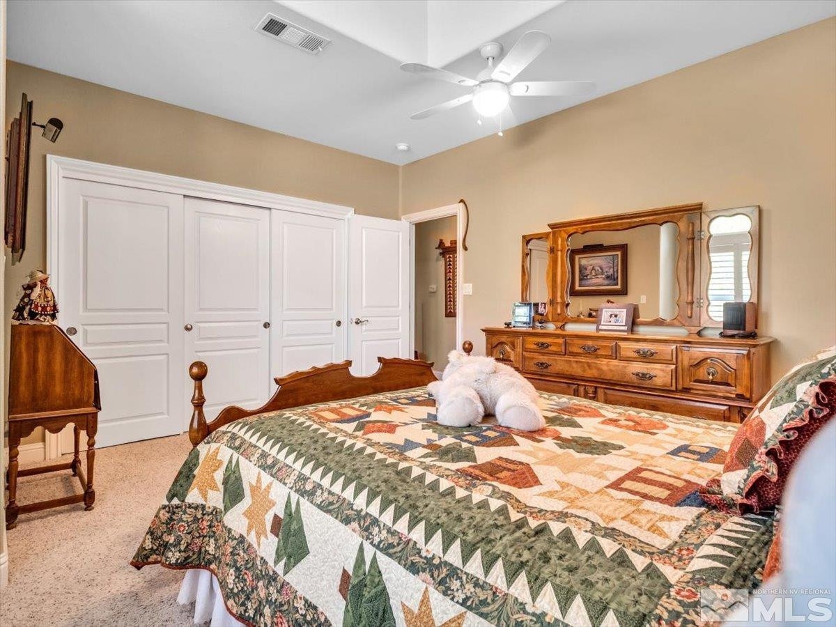 2034 Comstock Drive Gardnerville, NV 89410 - Photo 21 of 40 a bedroom with a bed and a chandelier