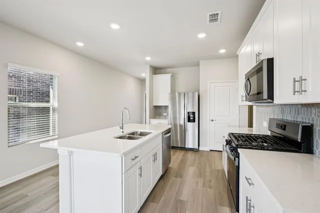 a kitchen that has a sink a stove and a refrigerator