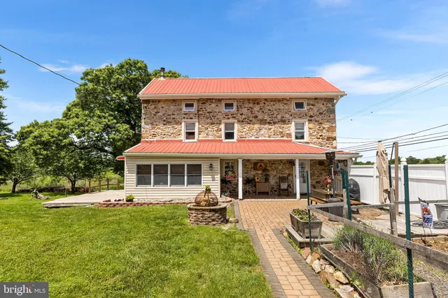 a view of a house with a yard patio and fire pit