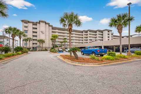 a front view of multi story residential apartment building with yard and outdoor seating