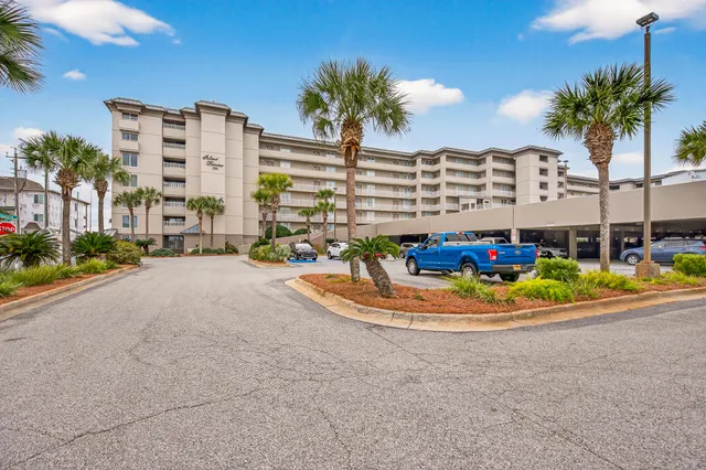 a front view of multi story residential apartment building with yard and outdoor seating