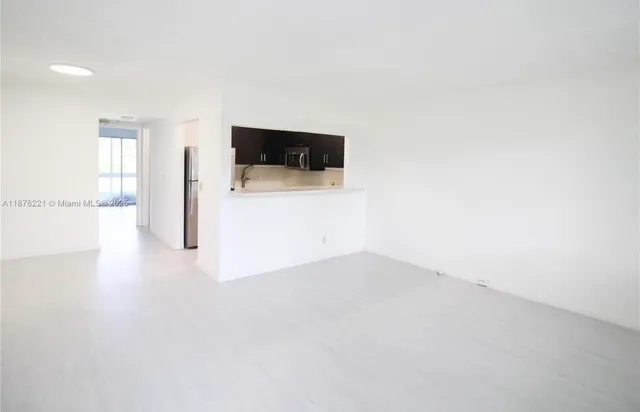 a view of a livingroom with wooden floor and a flat screen tv